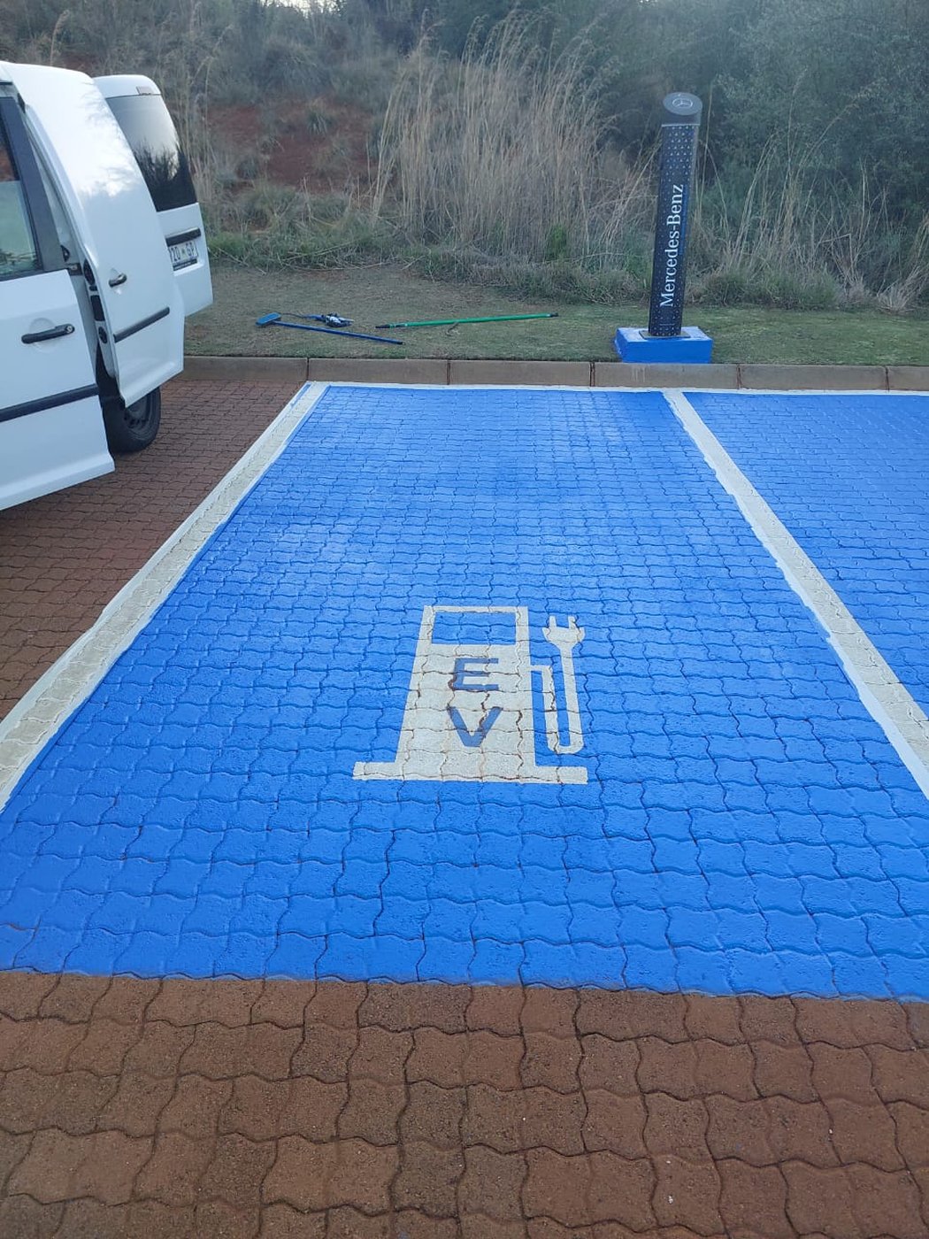 Blue-painted EV charging bay with Mercedes-Benz signage at a golf estate